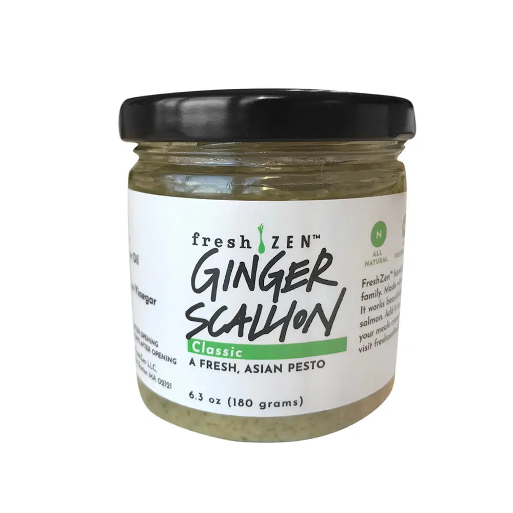 A glass jar with black lid of freshzen classic ginger scallion pesto labeled a fresh asian scallion classic weighing 6.3 oz